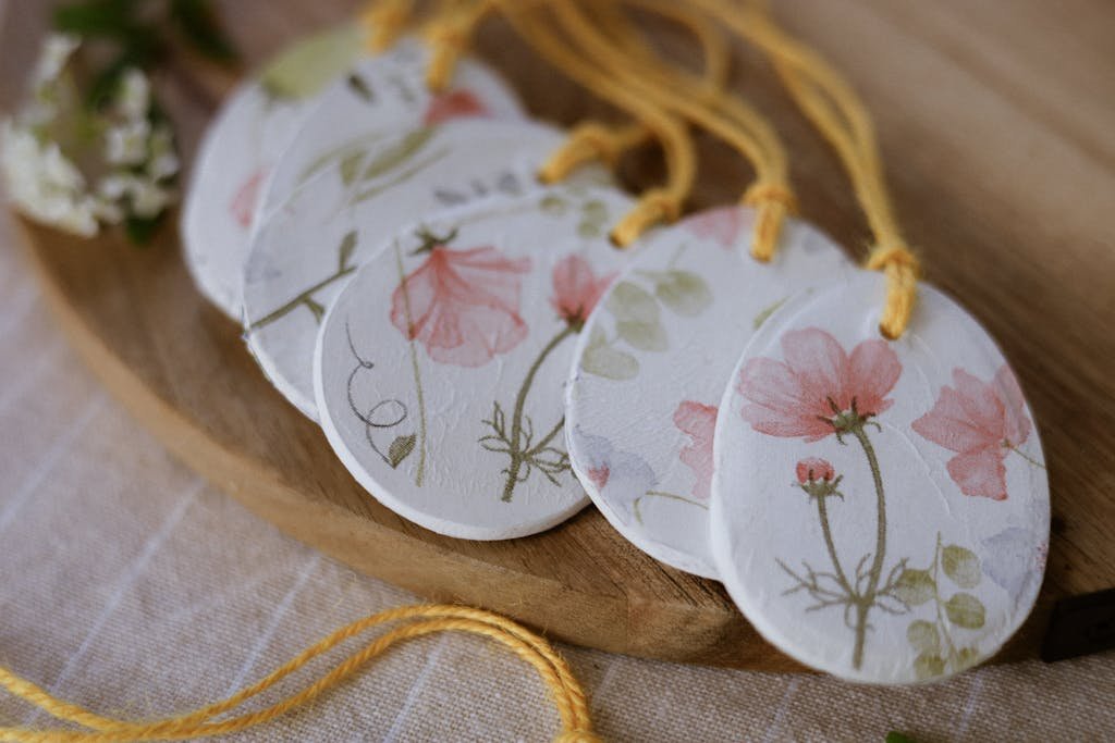 Set of handcrafted floral tags with yellow strings on a wooden dish.